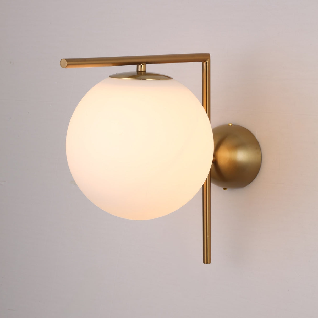 The Vetra 1 Light Opal Glass Wall/Semi-Flush Ceiling Light in gold features a round opal glass shade and brass fixture, adding elegance to any light-colored wall.