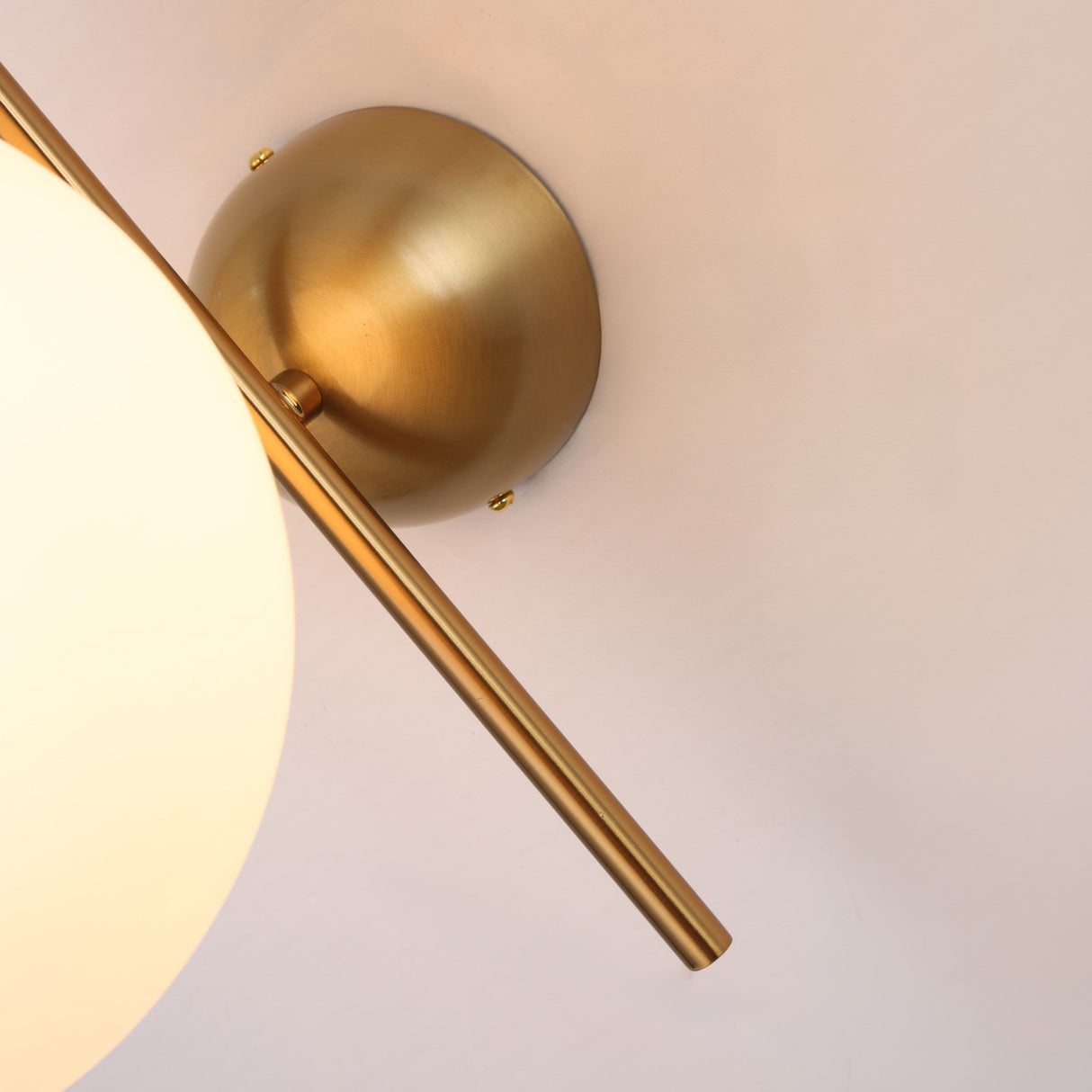 Close-up of the Vetra 1 Light Opal Glass Wall/Semi-Flush Ceiling Light in gold, featuring a round opal globe, angled gold rod, and metal base—ideal for modern wall or ceiling installations.