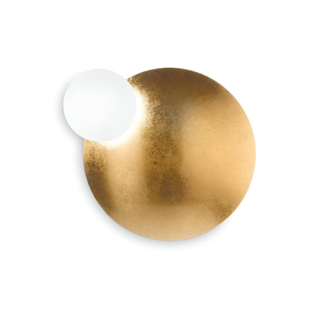 The Ocean Wall Light - Gold boasts a sculptural design featuring a large circular gold disc finished in gold leaf, with a smaller white circle elegantly positioned at the top left to cast an enchanting shadow. This minimalist design is further enhanced by an adjustable diffuser that allows for personalized illumination.