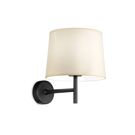 The Aethera Wall Light - White/Black is a contemporary wall-mounted sconce showcasing a sleek black arm with a round base and a cream-colored cylindrical lampshade. It offers a polished look against white surfaces and includes a convenient USB socket for extra functionality.