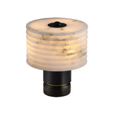 The Stravion 1 Light Small Ribbed Marble & Alabaster Table Lamp in soft white and black features a cylindrical ribbed marble shade with subtle gray veins on a short, round black metal base, emitting a warm, soft light.