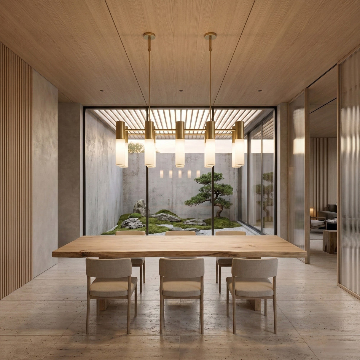 A minimalist dining room features a wooden table, six chairs, the Magari 10 Linear Suspension Light in gold above, and large glass doors opening to a tranquil Japanese-style garden with rocks and a bonsai tree.
