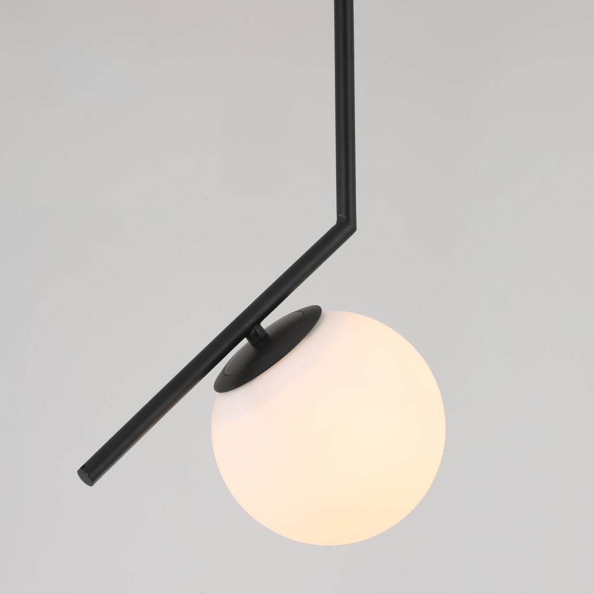 Niori Vetra Small Pendant Light with a 20cm opal glass globe on an angled matt black metal arm, shown against a light grey background.