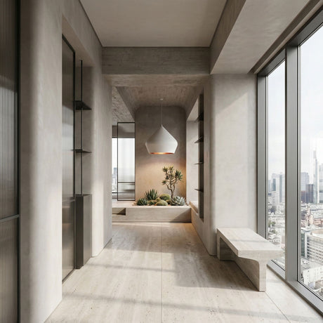 A minimalist modern interior features large windows with city views, a concrete bench, shelves, and a built-in planter with succulents beneath the white Funk Stout Large Pendant Light. Neutral tones and natural light fill the space.