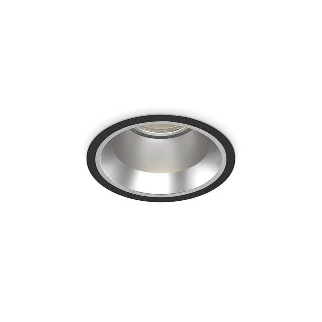 The IP54-rated Zeal Outdoor LED Recessed Downlight in black features a sleek, modern design and central light source. This 15W, 4000K minimalist fixture integrates seamlessly into the ceiling surface, offering both style and functionality.