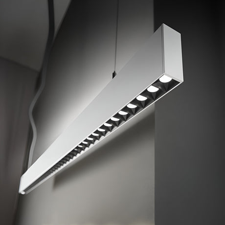 The Ignitia-1 LED Suspension Light 36W in white, with its sleek and modern rectangular design, hangs from the ceiling to highlight its aluminum construction. A row of exposed LED bulbs beneath it casts a soft 4000K glow against a simple, neutral-colored interior backdrop.