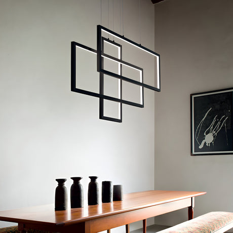A minimalist dining room is centered around a wooden table adorned with four black vases, while the Prios Rectangle LED Light Suspension 93W 3000K in Black, featuring an artistic geometric design, hangs elegantly above. A modern abstract black and white painting graces the wall, enhancing the sleek and contemporary atmosphere.