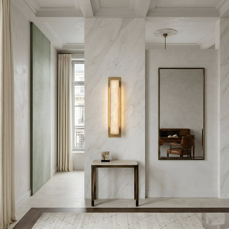 Minimalist hallway with marble-style walls, a narrow console table, tall cream curtains, large mirror, and a glimpse of a wooden desk and chair in an adjacent room, featuring the Astrielle LED Vertical Alabaster Wall Light in soft white & brushed brass.