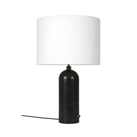 The Arvello 1 Light Minimal Marble Table Lamp - White & Black features a cylindrical black marble base, a large white drum shade, and a black power cord, all showcased against a plain white background.