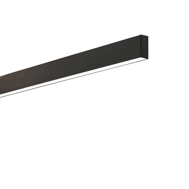 The Ignitia-1 LED Suspension Light 36W 3000K in black is a sleek, modern rectangular fixture mounted on a white wall. It emits soft, indirect lighting that highlights its minimalist design and enhances modern aesthetics.