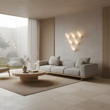 Niori Velari LED angled alabaster cylinder wall lights arranged in a chevron above a grey sofa in a minimalist living room with oak slatted walls.