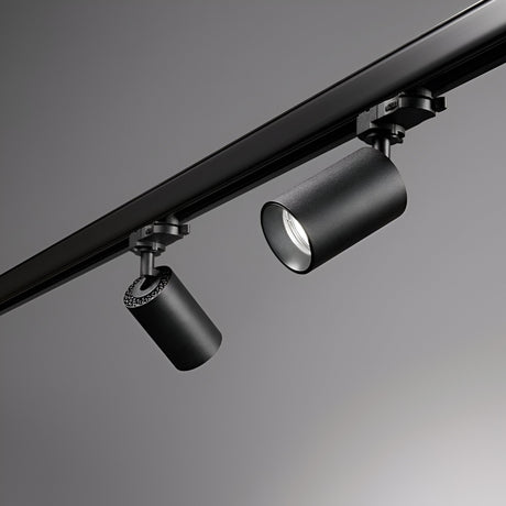 A detailed view of the Glimmera Three Phase Track Spotlight in black, showcasing its dual cylindrical fixtures with adjustable heads on a sleek track against a gray backdrop. The modern, minimalist design of these lights is complemented by a dimmable feature for versatile ambiance control.