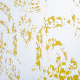 Close-up of the Oxide Bronze Printed Glass Wall Mirror, frameless glass panel with a mottled gold pattern dense at the edges and thinning toward a clear central area.
