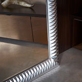 Nick Silver Leaf full length wall mirror, corner detail showing faceted silver leaf frame with pyramid-fold texture, reflecting a room with dark cabinetry.