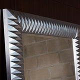 Nick Silver Leaf Full Length Mirror 189cm, close-up of the faceted pyramid-textured frame in silver leaf finish, mounted on a dark wood panelled wall.