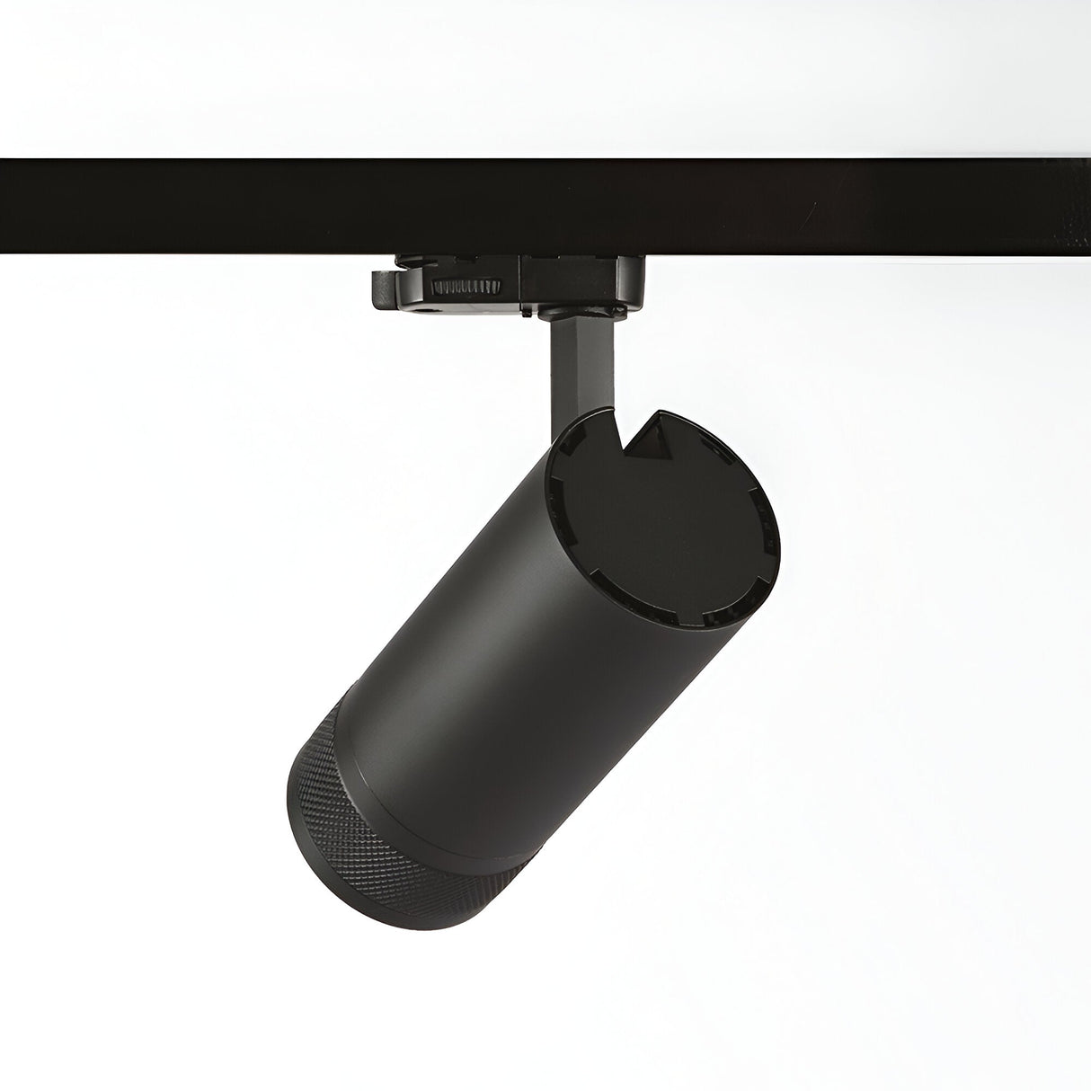 The Solis Three Phase LED Track Spotlight 15W 3000K - Black is a sleek, black cylindrical fixture with a textured base, designed to attach to a ceiling rail and angle downward. This adjustable lighting solution brings modern elegance to any space. The plain white background accentuates its contemporary design.