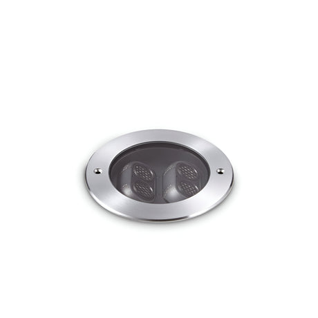 A round, grey recessed ceiling light with two black inner components set against a plain white background. This elegant fixture reflects the durability of the Zephyra Outdoor LED Round Recessed Ground Light, featuring an IP67 rating and 11W power with a warm 3000K color temperature.