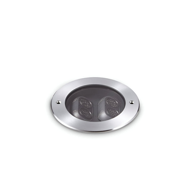 A round, grey recessed ceiling light with two black inner components set against a plain white background. This elegant fixture reflects the durability of the Zephyra Outdoor LED Round Recessed Ground Light, featuring an IP67 rating and 11W power with a warm 3000K color temperature.