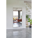 Lucka Gold Framed Full Length Mirror, 175cm rectangular wall mirror with slim gold metal frame, shown reflecting a living room with sofa and floor-to-ceiling windows beside a staircase.