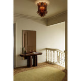 Lucka Bronze Tinted Full Length Mirror 175cm in a slim black metal frame, mounted above a dark wood console table in a hallway with a ceiling pendant light.