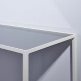 Close-up of the Mesa White console table's corner, showing the slim white metal frame and grey mirrored glass top and side panel.