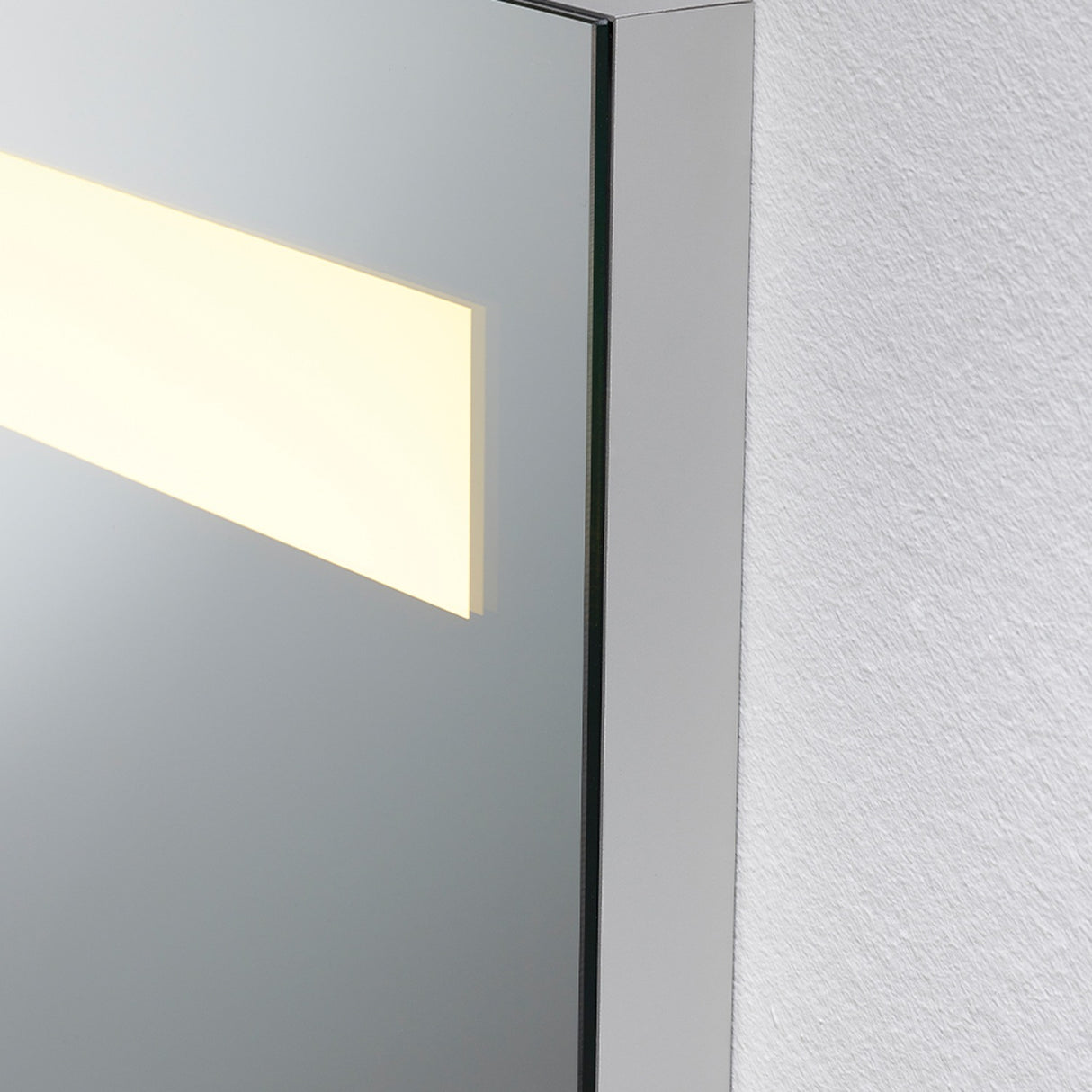 Corner close-up of the B.Light Backlit LED Square Bathroom Mirror 70cm, showing the mirrored edge with a warm illuminated strip inset in the glass against a white wall.