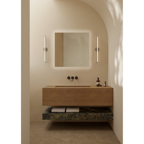 B.Ambi square backlit LED bathroom mirror, 70cm, wall-mounted above a wooden vanity with black wall-mounted taps in a neutral, arched bathroom setting.