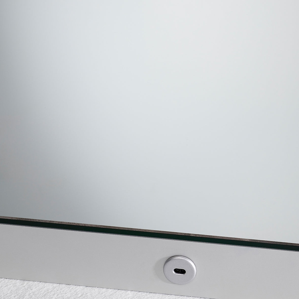 Close-up of the B.Ambi backlit LED square bathroom mirror 70cm, showing the glass edge with a metal frame and a round touch sensor set into the lower border.