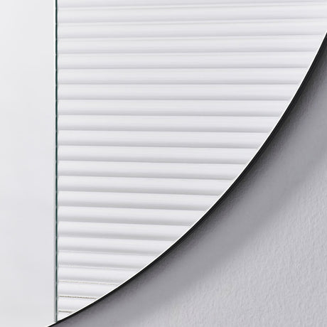 Close-up of the Cord Flutes round wall mirror's edge, showing fine horizontal reeded glass ribbing meeting the curved frameless border, set against a plain light background.