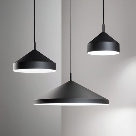 Three sleek Elysian 1 Light Pendant lamps in black, measuring 50cm each, hang from the ceiling in a minimalist setting. These cone-shaped lights come with dimmable functionality and vary in size to cast a gentle white glow, enhancing the simple elegance of the light gray walls.
