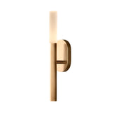 The Aurelian LED Vertical Column Alabaster Wall Light features a brushed brass base and a soft white alabaster shade, creating a modern look when mounted against a white background.