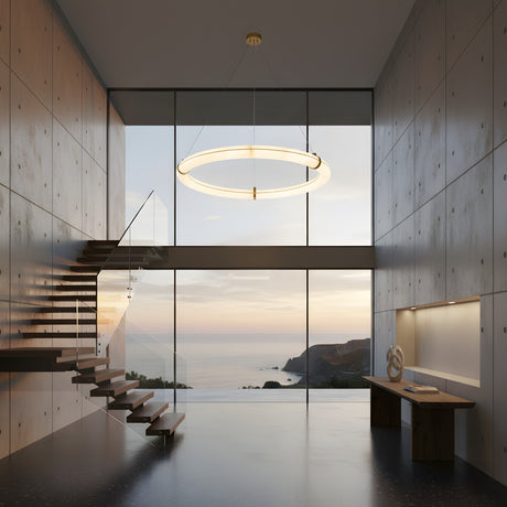A modern minimalist room with concrete walls, floating wooden stairs, floor-to-ceiling sunset ocean views, and an Aureon LED Small Alabaster Circular Suspension Light in soft white. A simple bench with decor sits against one wall.