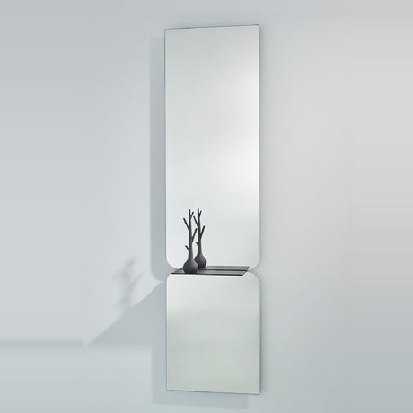 Taille full length hall mirror, 180cm, frameless rectangular glass in two panes with rounded join and black metal shelf, shown on a plain light grey wall.