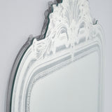 Close-up of the Haussmann full length mirror's scrolled crest and etched glass border, showing the moulded frameless design against a plain light background.