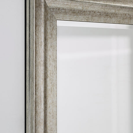 Close-up of the Metz full length mirror's corner, showing a stepped, moulded frame in a broken silver finish with a darker ground visible in the grooves.