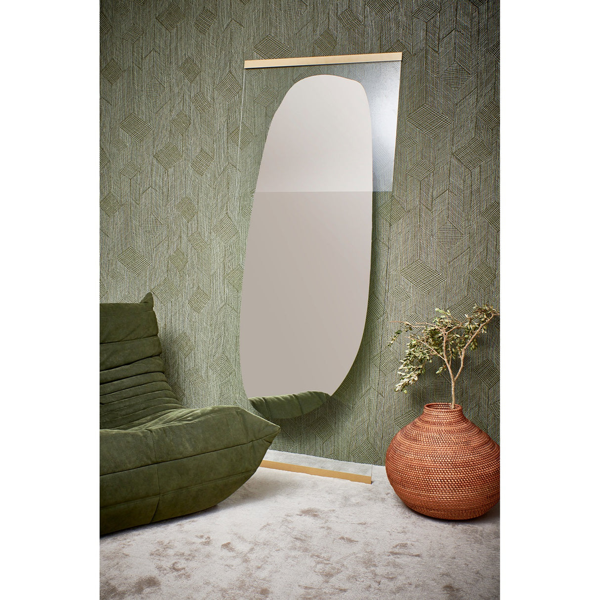 Gold-framed Obu Organic Full Length Leaning Mirror, 178cm, featuring a silvered rock-shaped design, leaning against green wallpaper beside a green sofa and terracotta planter.