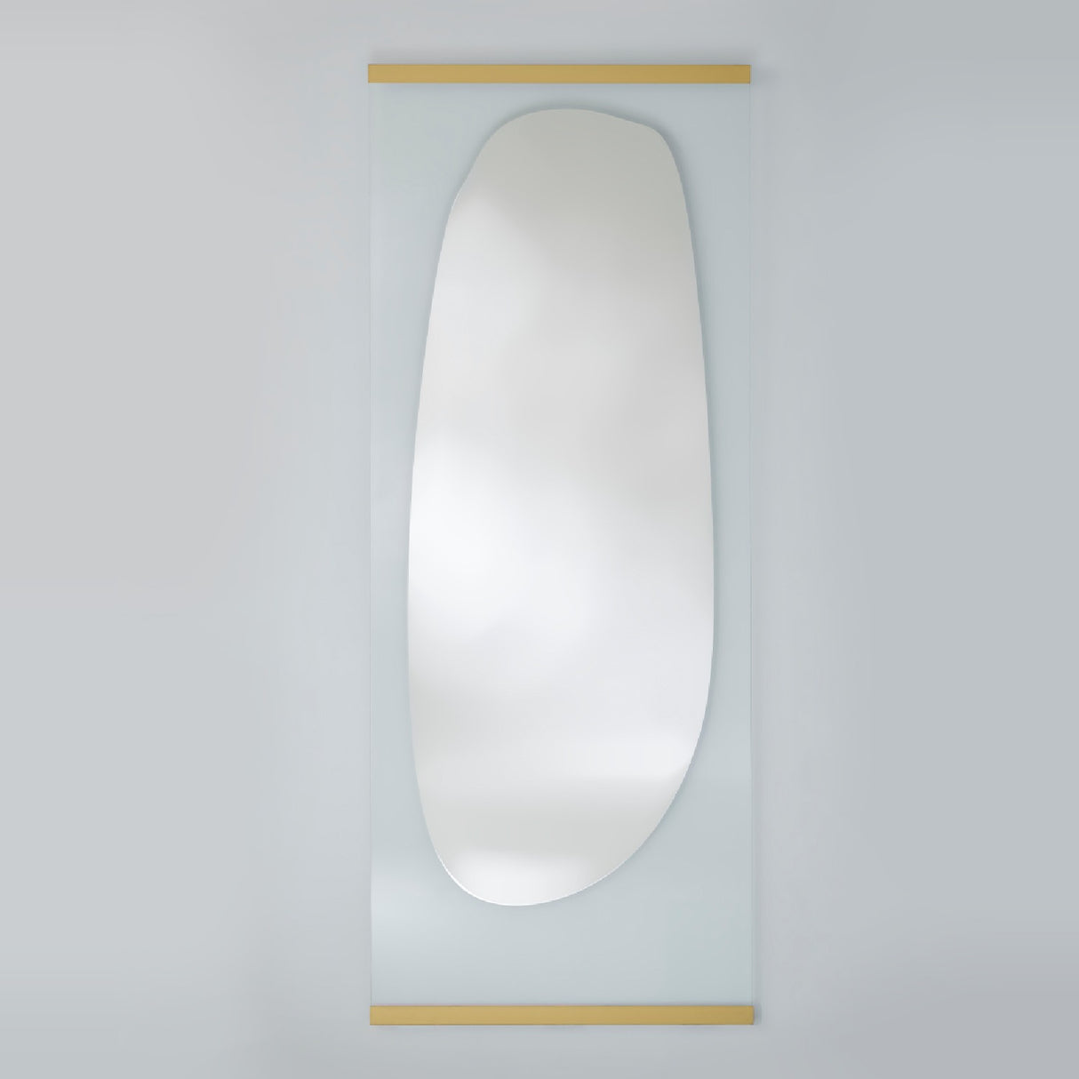 Full length leaning mirror with an organic silvered shape on clear glass, held by slim gold bars at the top and bottom.