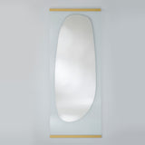 Full length leaning mirror with an organic silvered shape on clear glass, held by slim gold bars at the top and bottom.