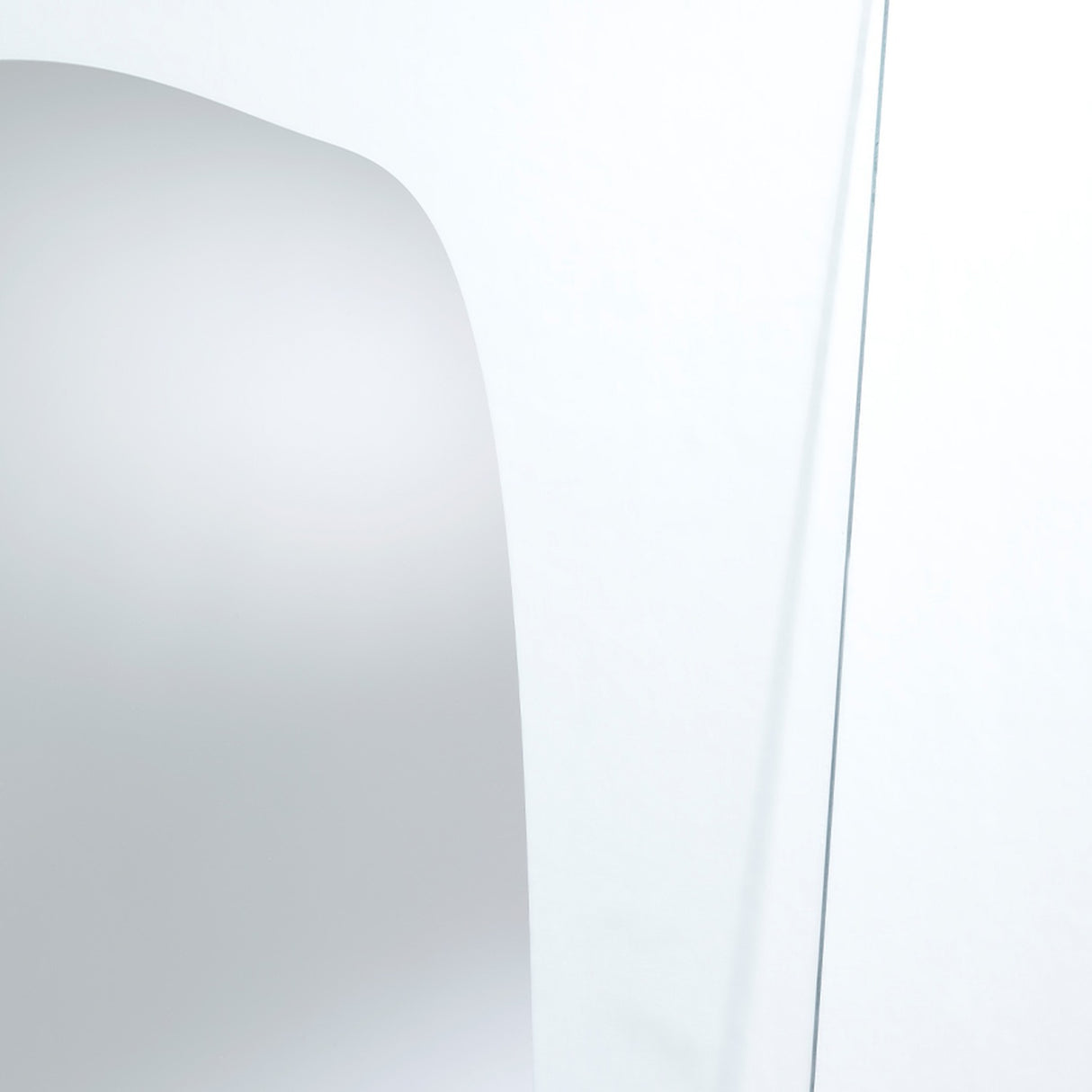 Close-up of the silvered shape meeting the clear glass, the edge of the reflection fading out into transparency.