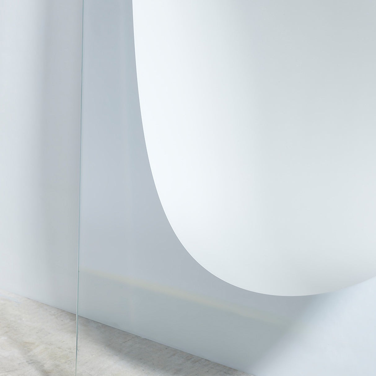 Close-up of the lower curve and the gold bar that runs across the foot of the clear glass panel.