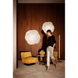 Arbo Gold Tree Ring Printed Glass Wall Mirror 80cm, two round frameless mirrors with gold sawn-edge trunk-ring design, mounted on a dark wood-panelled wall in a living room setting.