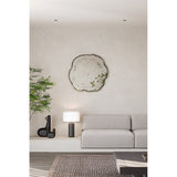 Arbo Dark Tree Ring Printed Glass Wall Mirror 80cm, frameless irregular tree-slice shape with charcoal bark-like edge, shown mounted above a sofa in a neutral living room.