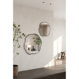 Arbo Dark Tree Ring Printed Glass Wall Mirror 80cm with irregular tree-slice outline and charcoal bark-like edge, shown alongside a matching smaller mirror on a light hallway wall.