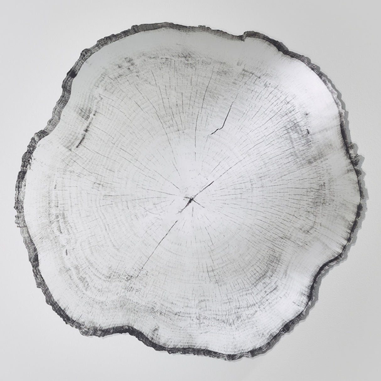 Arbo Dark frameless wall mirror with irregular tree ring-effect printed glass face and dark uneven edge, shown on a plain white background.