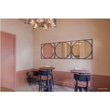 Circo Square Printed Glass Wall Mirror, three black-framed circular panels in a row above a dining area with round tables, dark chairs, and a pink half-painted wall.
