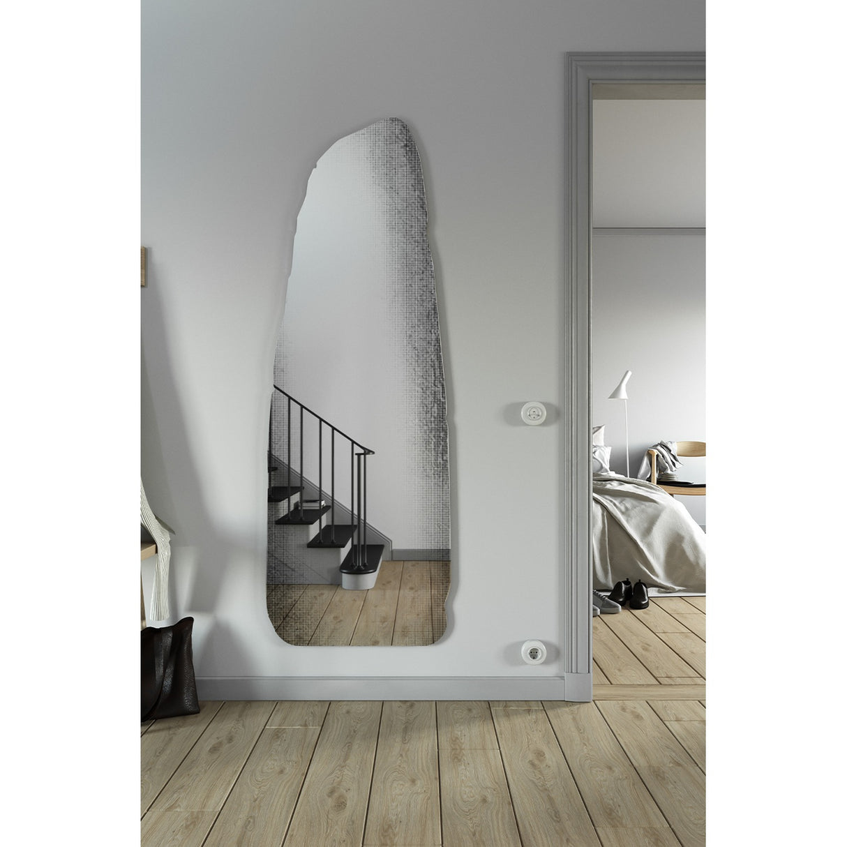 Rocca Standing Stone Printed Glass Wall Mirror 175cm, a frameless irregular mirror shaped like a menhir with a screen-printed stone pattern, mounted in a hallway near a staircase.