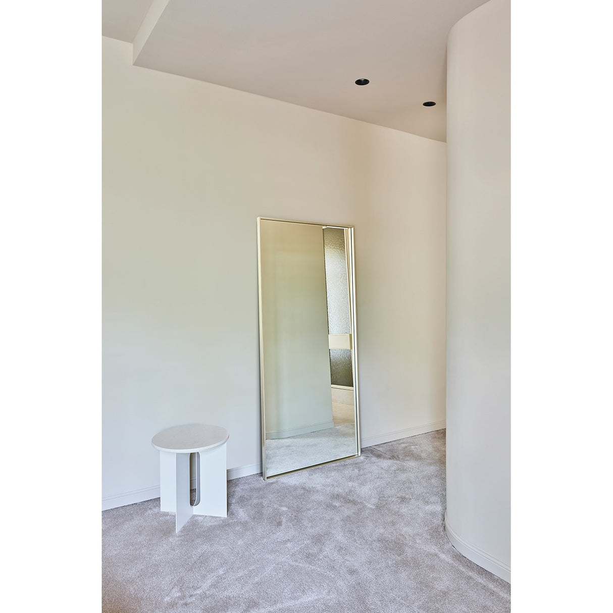 Soho Silver Slim Framed Full Length Mirror 176cm leaning against a light wall in a bedroom, rectangular glass with a narrow flat silver frame, beside a small round white stool.