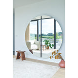 Luna Black Two Piece Round Wall Mirror 200cm, frameless glass with a black lacquered central joint, hung in a living room reflecting a sofa and garden view.