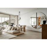 Round black-framed wall mirror by Luna, 200cm, mounted in a living room, showing a recessed black glass strip at its central joint reflecting the space.