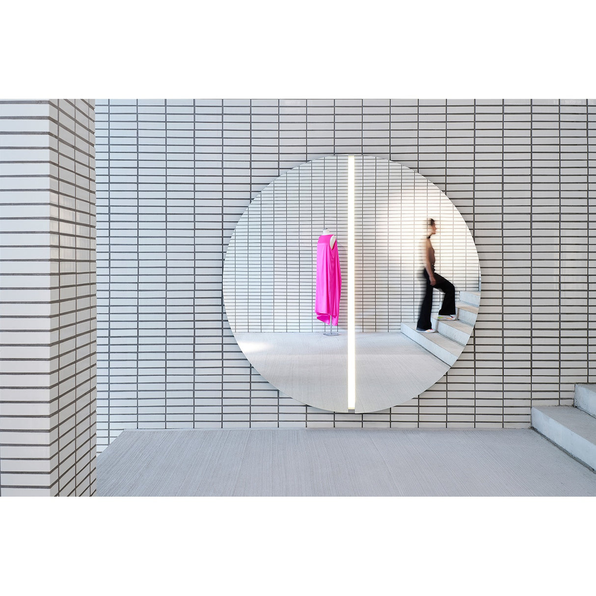Luna Light LED Two Piece Round Wall Mirror 200cm, a large frameless round mirror split into two halves with a vertical LED strip at the centre seam, mounted on a white tiled wall.